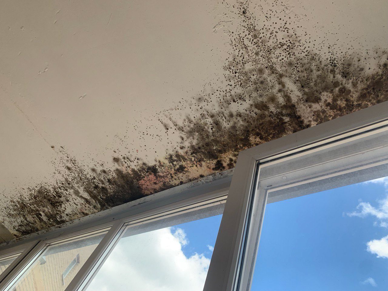 Schimmel op plafond bij raamkozijn door condens